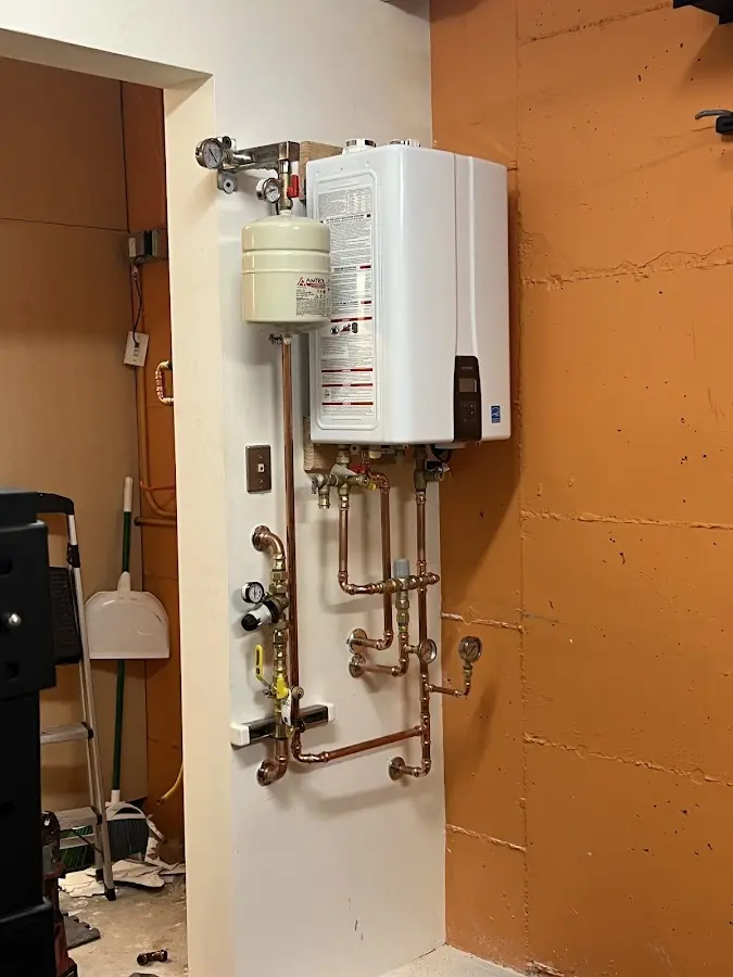 Plumbing technician inspecting water heater connections in Shelter Island